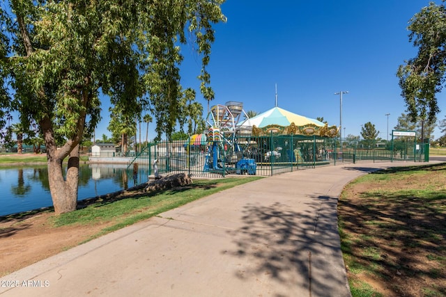 view of home's community featuring fence and a water view