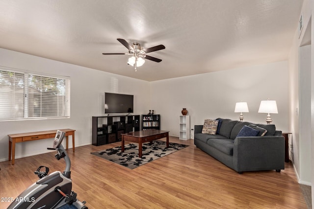 living area with ceiling fan, wood finished floors, and baseboards