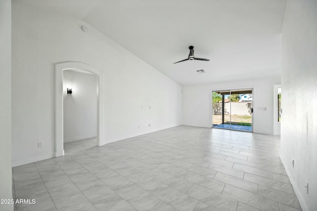 unfurnished living room featuring arched walkways, ceiling fan, and vaulted ceiling