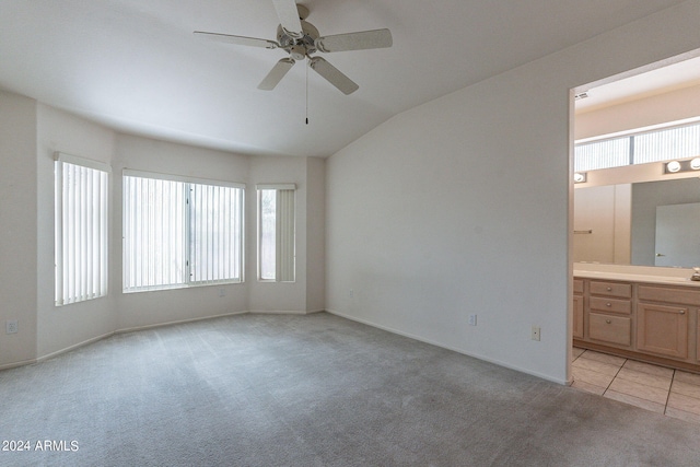 empty room with ceiling fan, light colored carpet, lofted ceiling, and a healthy amount of sunlight