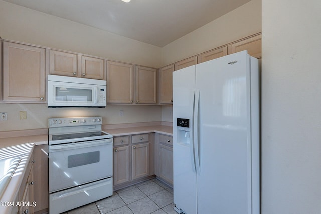 kitchen featuring light brown cabinets, light tile patterned floors, and white appliances