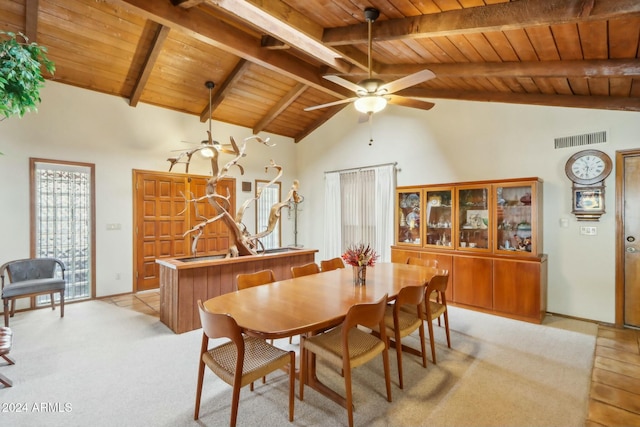 dining area featuring beamed ceiling, high vaulted ceiling, wood ceiling, and light colored carpet