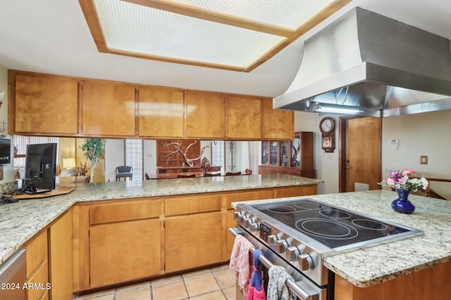 kitchen with light stone countertops, light tile patterned floors, island range hood, kitchen peninsula, and stainless steel appliances