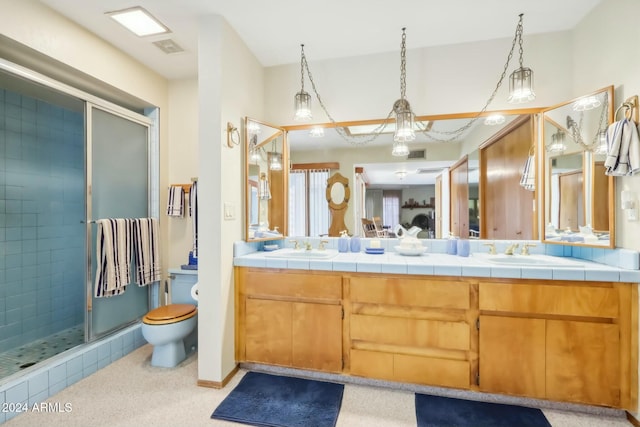 bathroom featuring vanity, toilet, and a shower with shower door