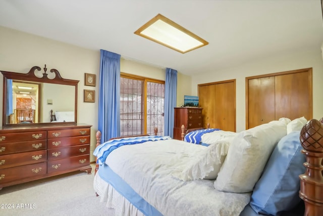 bedroom with light carpet and multiple closets