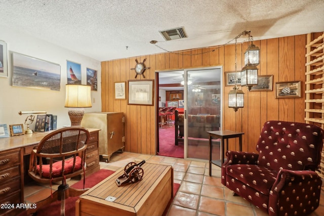 interior space featuring wood walls, light tile patterned floors, and a textured ceiling