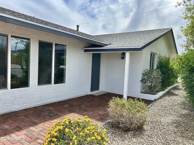 6923 E Hubbell St, Scottsdale, AZ 85257 - view of exterior entry featuring stucco siding, a shingled roof, and a patio