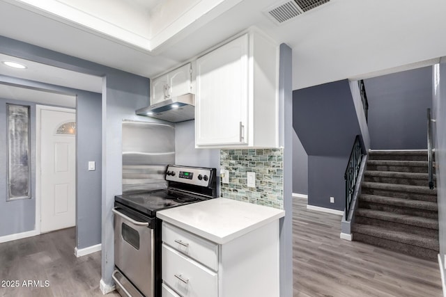 kitchen with hardwood / wood-style flooring, white cabinets, tasteful backsplash, and stainless steel range with electric cooktop