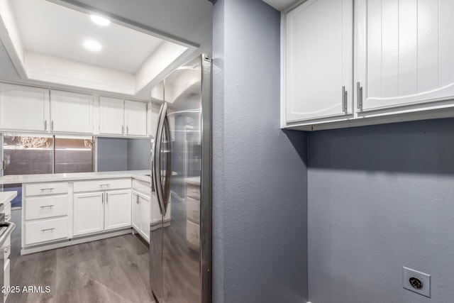 laundry area featuring hardwood / wood-style flooring, cabinets, and electric dryer hookup