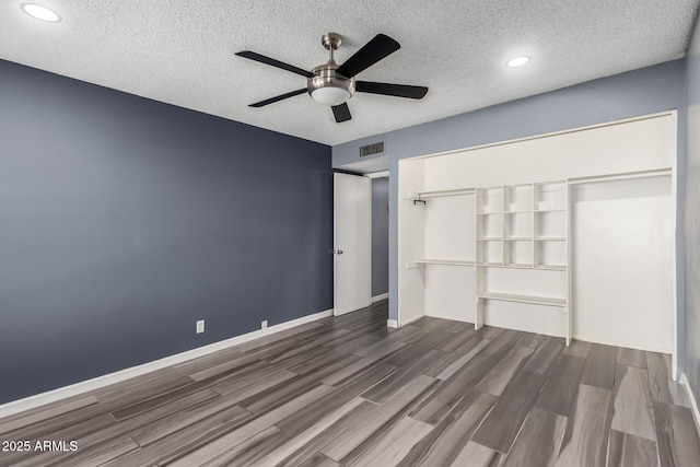 unfurnished bedroom featuring a textured ceiling, a closet, hardwood / wood-style flooring, and ceiling fan