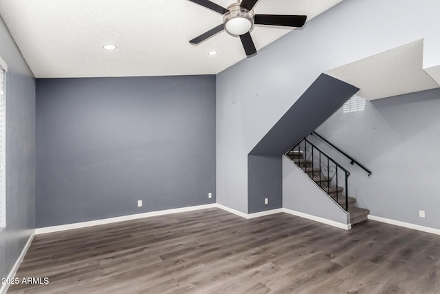 unfurnished living room with ceiling fan and dark wood-type flooring