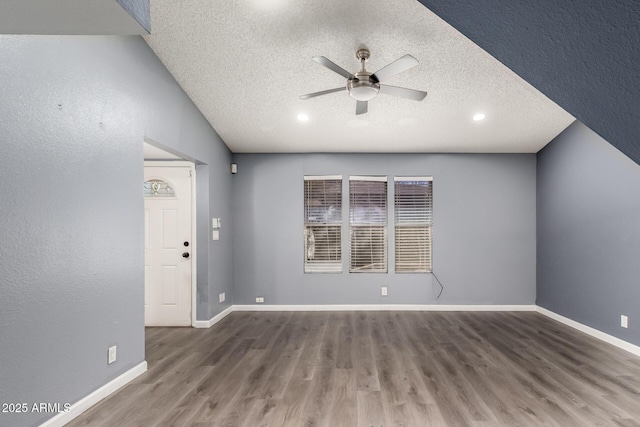 empty room with ceiling fan, dark wood-type flooring, and a textured ceiling