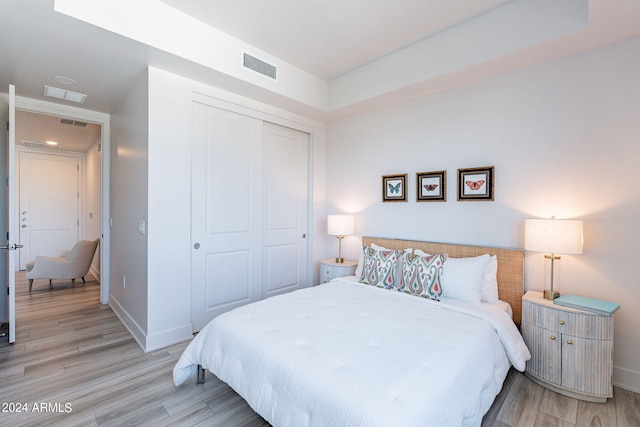 bedroom with light hardwood / wood-style flooring and a closet