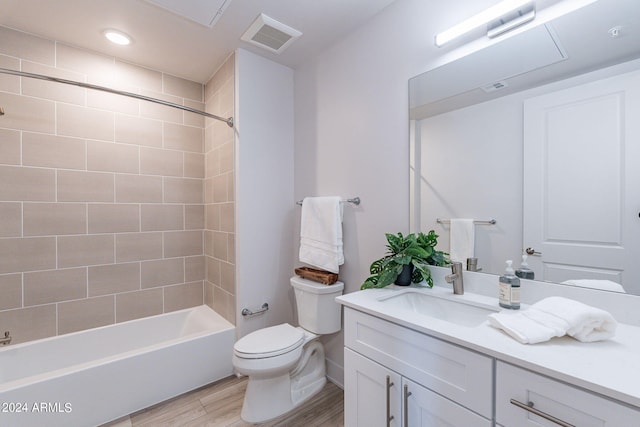 full bathroom featuring toilet, hardwood / wood-style floors, vanity, and tiled shower / bath