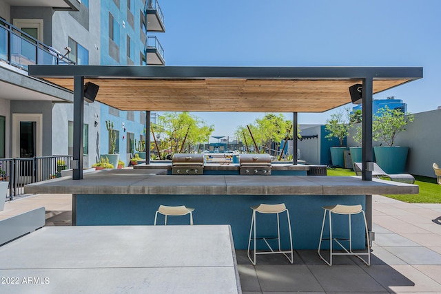 view of patio / terrace featuring an outdoor kitchen, area for grilling, and exterior bar