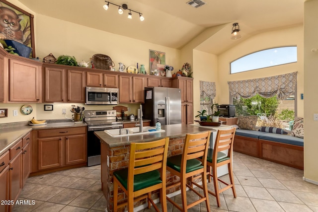 6031 N Milano Ct, Litchfield Park, AZ 85340 - kitchen with appliances with stainless steel finishes, light tile patterned flooring, a sink, open floor plan, and high vaulted ceiling