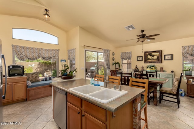 6031 N Milano Ct, Litchfield Park, AZ 85340 - kitchen featuring dishwasher, a sink, lofted ceiling, light tile patterned flooring, and an island with sink
