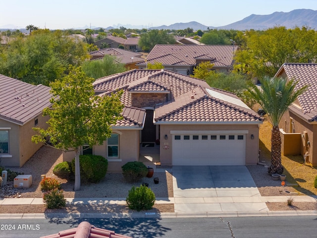 view of front of home with a mountain view and a garage