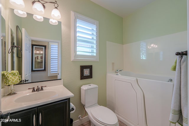 bathroom with vanity, toilet, and a tub