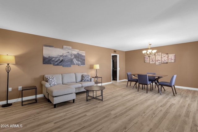 living room with an inviting chandelier and light wood-type flooring