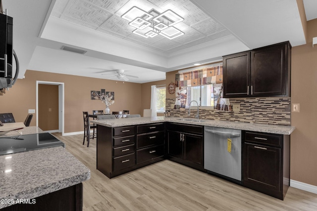 kitchen with sink, tasteful backsplash, stainless steel dishwasher, kitchen peninsula, and light wood-type flooring