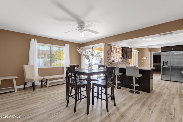 dining room with ceiling fan and light wood-type flooring