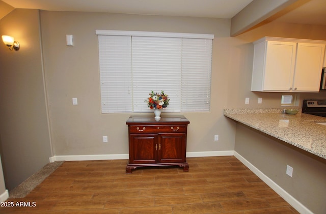 2150 W Alameda Rd Unit 1109, Phoenix, AZ 85085 - kitchen with stainless steel electric range oven, wood finished floors, white cabinets, and light stone counters