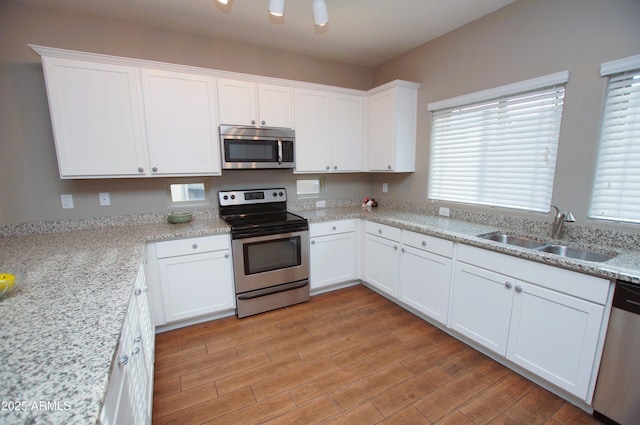 2150 W Alameda Rd Unit 1109, Phoenix, AZ 85085 - kitchen with appliances with stainless steel finishes, a sink, white cabinets, light wood finished floors, and plenty of natural light