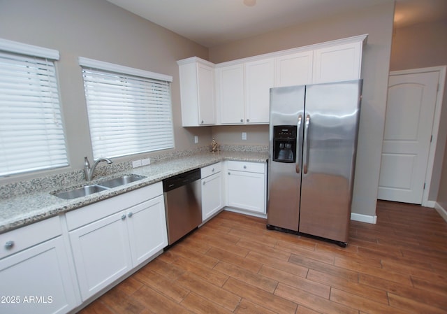 2150 W Alameda Rd Unit 1109, Phoenix, AZ 85085 - kitchen featuring appliances with stainless steel finishes, a sink, white cabinetry, light wood-type flooring, and light stone countertops
