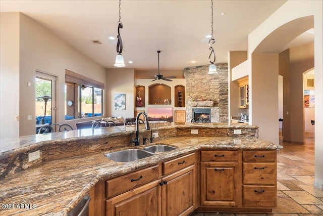 kitchen featuring brown cabinets, visible vents, open floor plan, and a sink