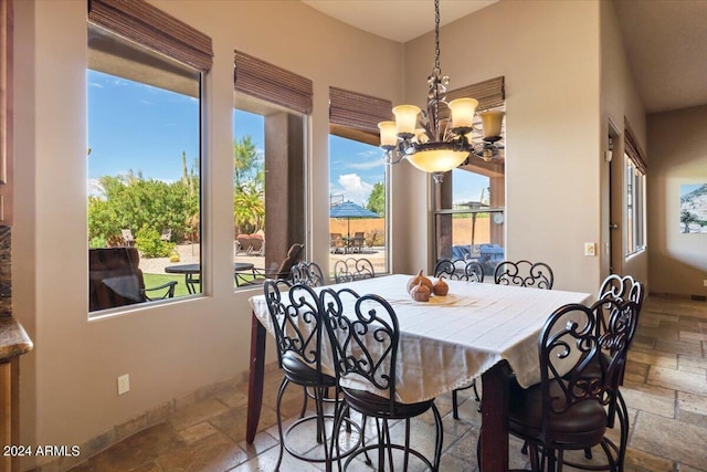 dining space featuring stone tile flooring and an inviting chandelier