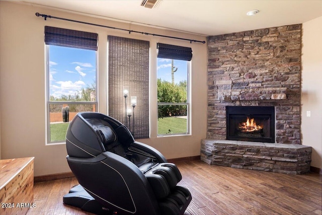 living room with a fireplace, baseboards, and wood finished floors