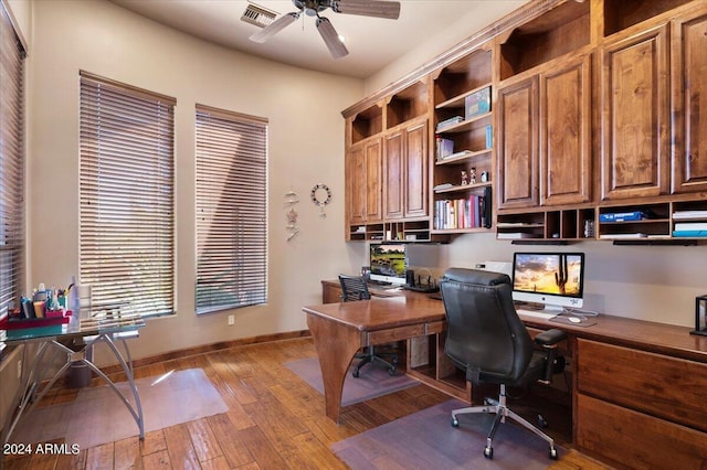 home office featuring baseboards, ceiling fan, visible vents, and hardwood / wood-style floors