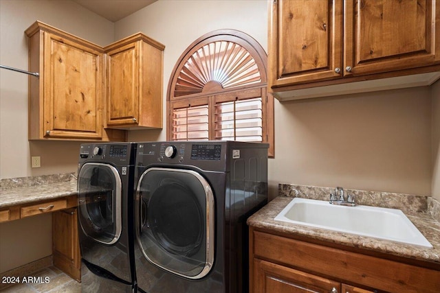 laundry room with separate washer and dryer, a sink, and cabinet space