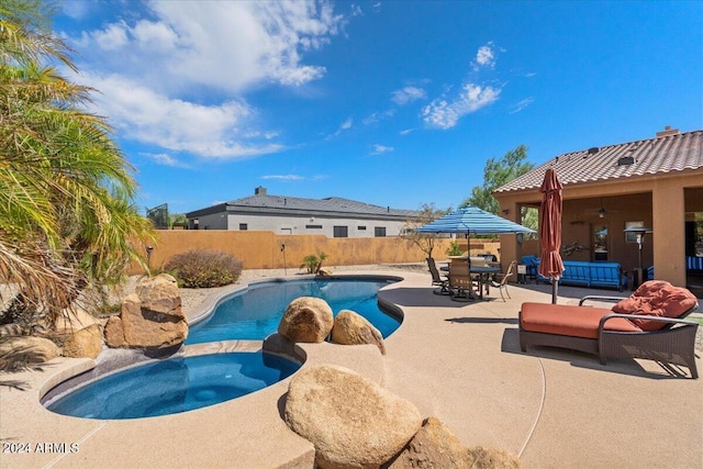 view of pool featuring a patio, outdoor dining area, fence, and a pool with connected hot tub