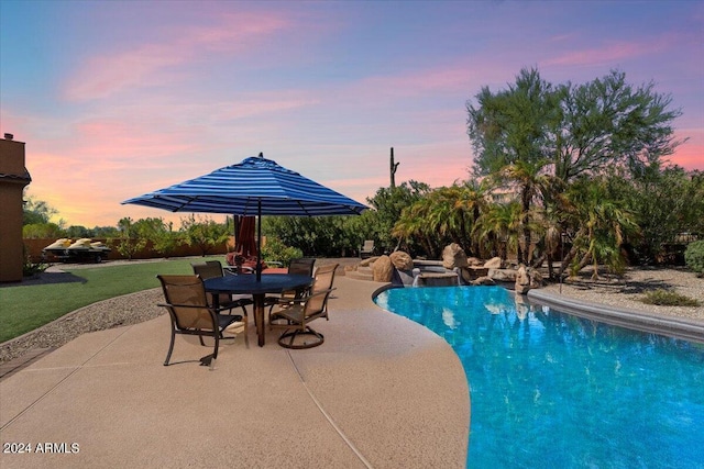 pool with outdoor dining space, a patio, and a lawn