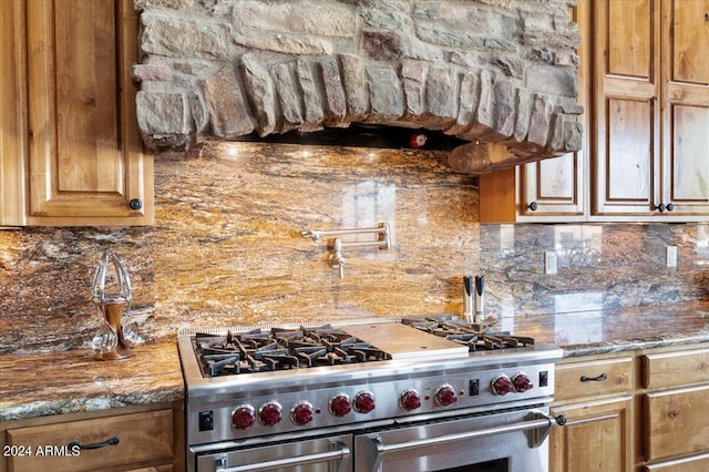 kitchen with range with two ovens, brown cabinetry, and decorative backsplash