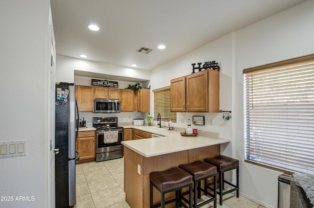 2325 S 88th Dr, Tolleson, AZ 85353 - kitchen featuring a breakfast bar, sink, light tile patterned floors, appliances with stainless steel finishes, and kitchen peninsula