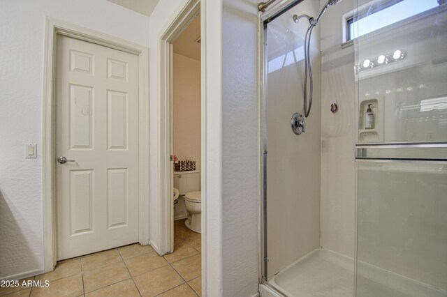 2325 S 88th Dr, Tolleson, AZ 85353 - bathroom featuring tile patterned floors, toilet, and a shower with shower door