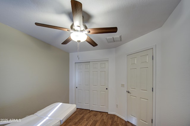 2325 S 88th Dr, Tolleson, AZ 85353 - unfurnished bedroom with dark wood-type flooring, ceiling fan, and a closet