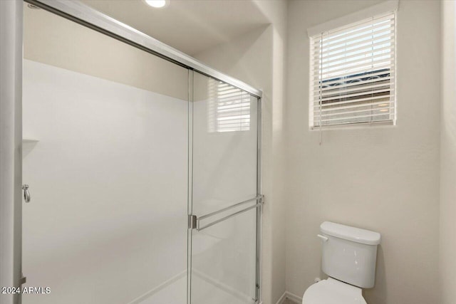 bathroom featuring toilet and an enclosed shower