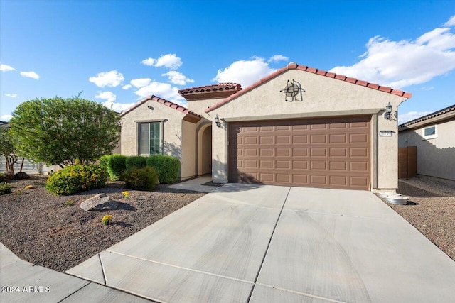 mediterranean / spanish-style home with a garage