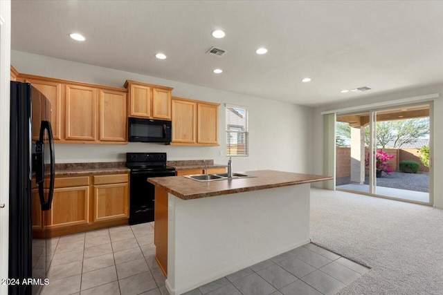 kitchen with light carpet, black appliances, sink, and a center island with sink