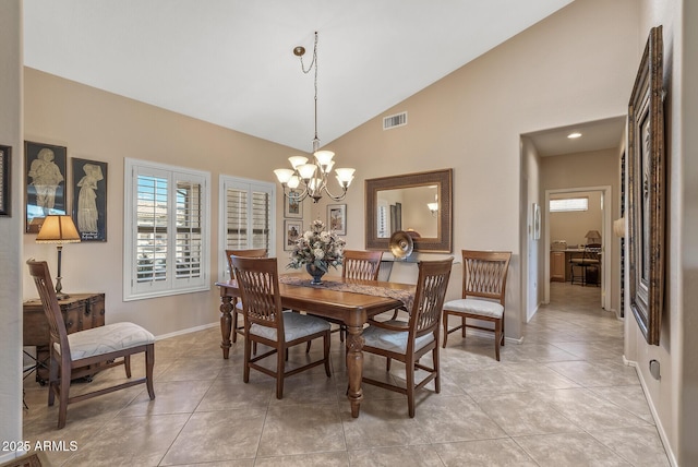 dining room with high vaulted ceiling, light tile patterned floors, visible vents, a chandelier, and baseboards