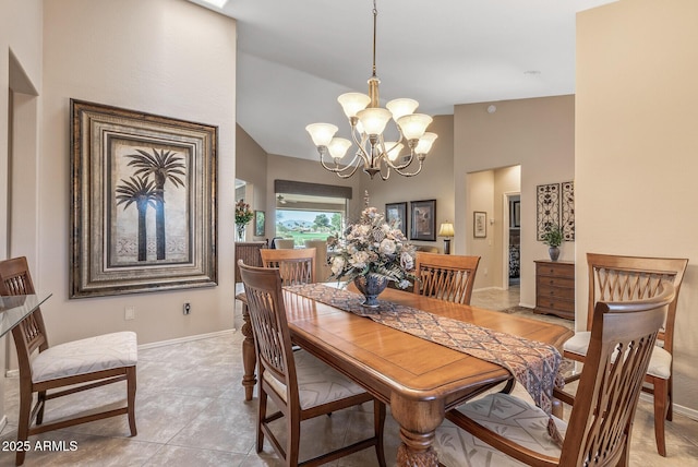 dining room with vaulted ceiling, baseboards, and a notable chandelier