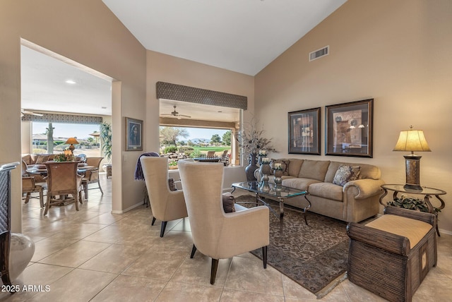 living area with high vaulted ceiling, baseboards, light tile patterned floors, and visible vents