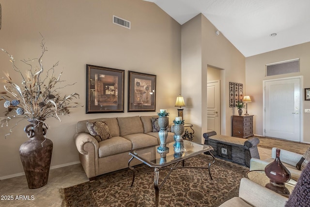 tiled living room with high vaulted ceiling, visible vents, and baseboards