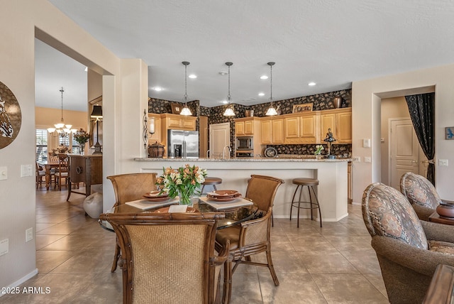 dining room with light tile patterned floors, recessed lighting, baseboards, and a notable chandelier