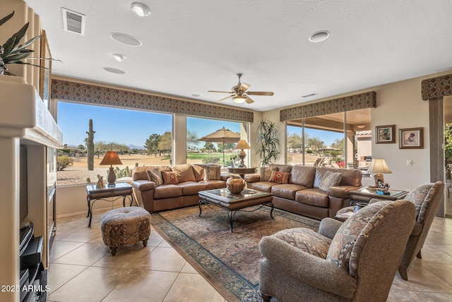 living room featuring light tile patterned floors, ceiling fan, and visible vents