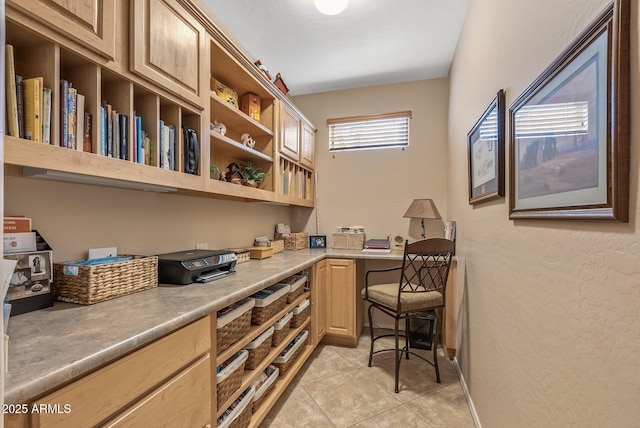 office area featuring built in desk and light tile patterned floors